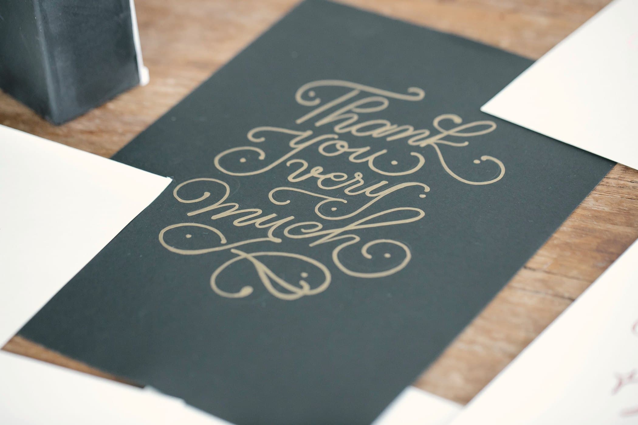 Gold script lettering on a dark green card