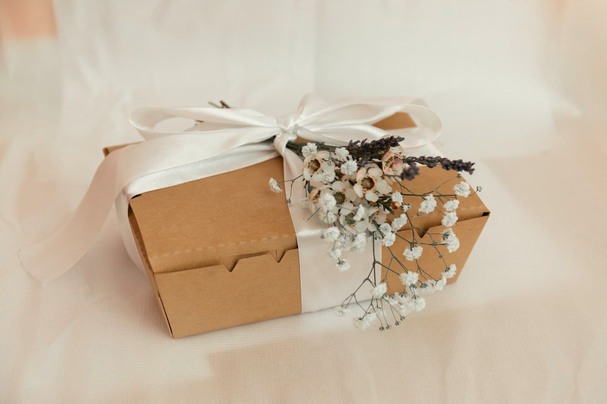 Kraft box tied with a cream ribbon and dried flowers