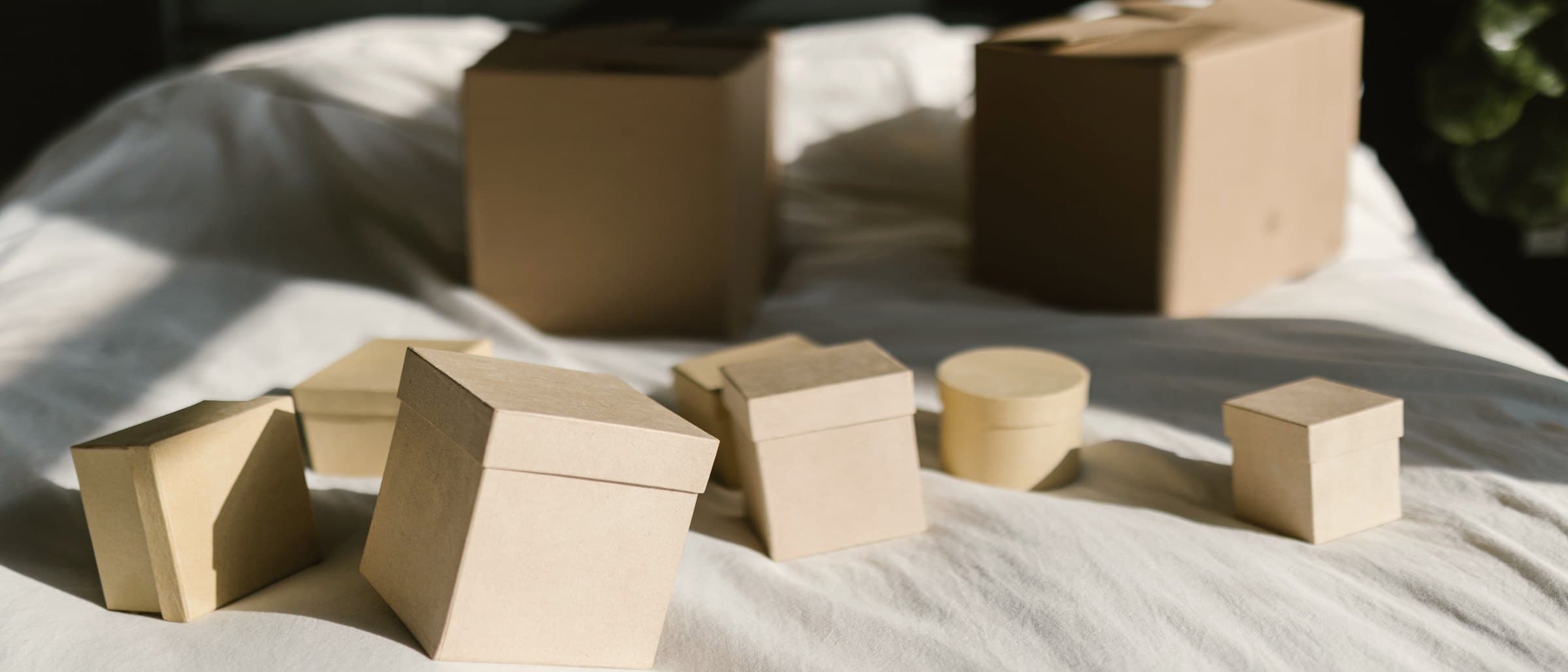 Wrapped gift boxes, tissue and ribbon laid out across a wooden table