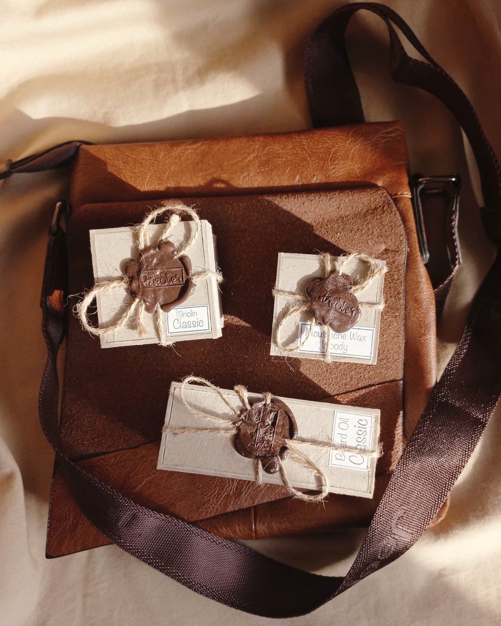 Kraft-wrapped gifts with wax seals and twine on a leather bag