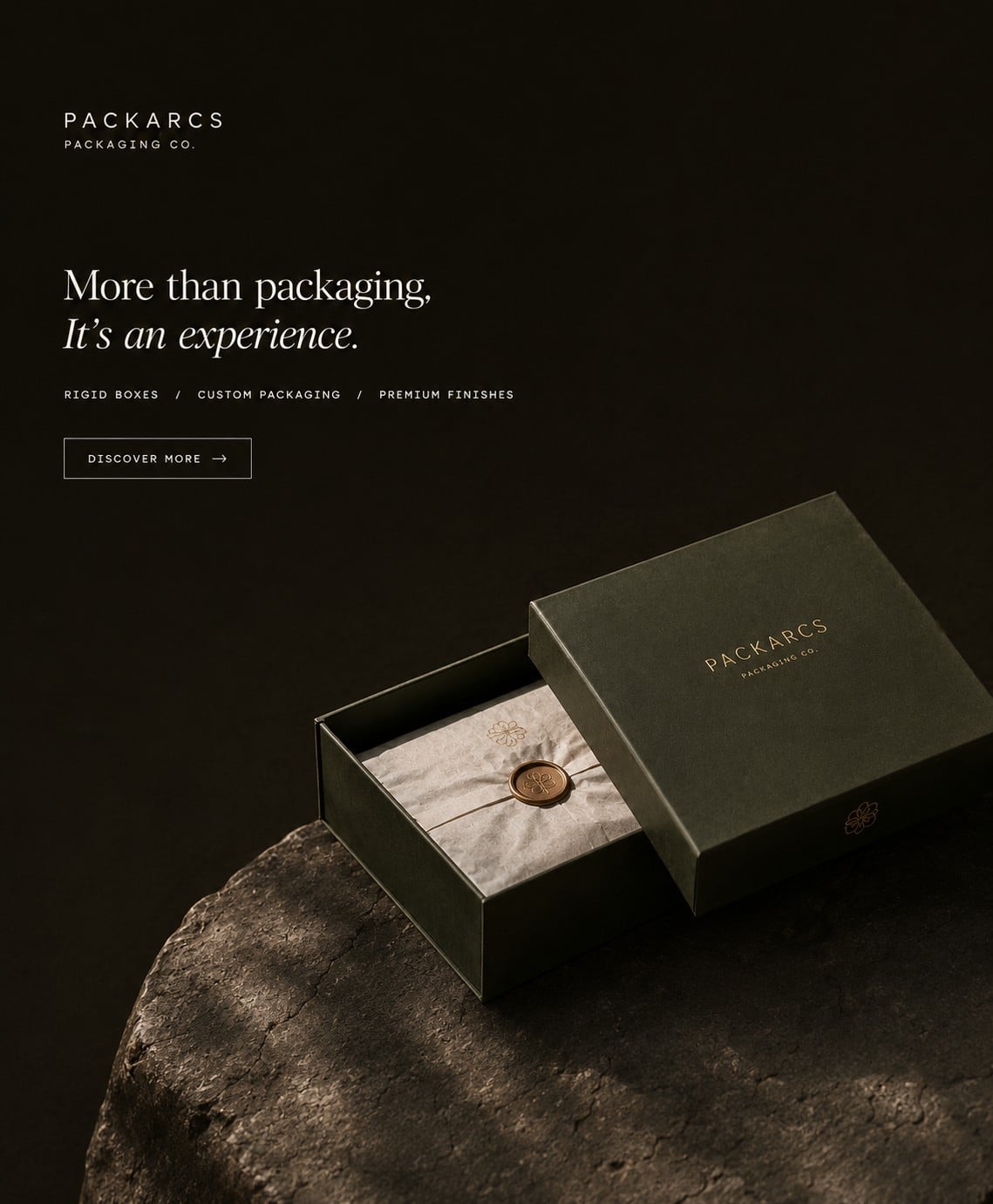 Forest green drawer box opened on a rock, tissue sealed with a bronze wax seal. More than packaging, it's an experience.